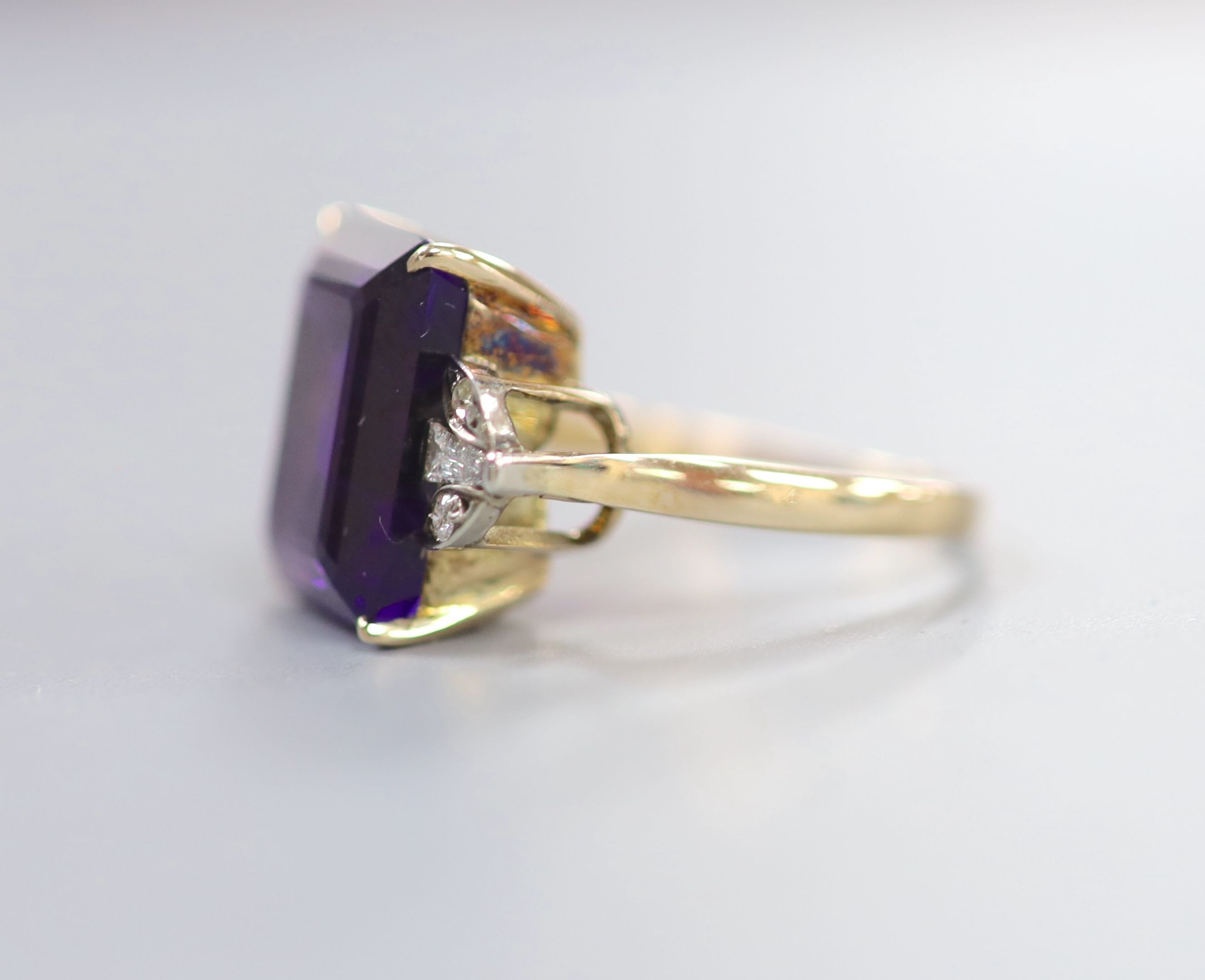 A yellow metal and single stone emerald cut amethyst dress ring, with trapeze and round cut diamond set shoulders, size P, gross weight 6.1 grams.